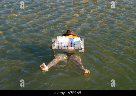 Un homme lit un document dans le lac de sel avec une concentration de sel 7 fois plus élevé que la mer près du village de beachport south Banque D'Images