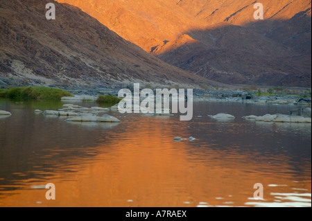 Tôt le matin, la lumière sur les montagnes du Richtersveld stérile reflète dans la rivière Orange du nord du Richtersveld Banque D'Images