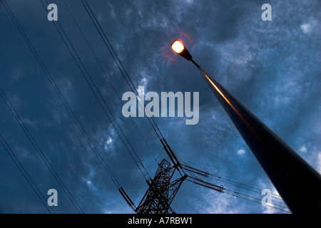 Pylône de l'électricité au crépuscule avec lampe de rue lumineux Banque D'Images