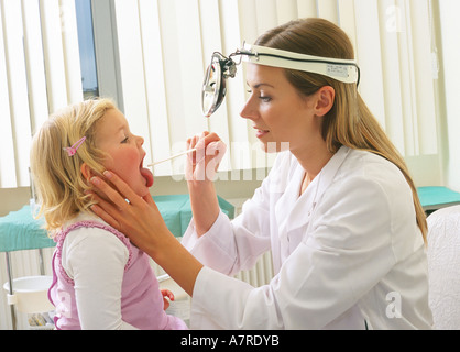 À l'intérieur du cabinet ambulatoire mature femme fille enfant 30 35 510 blonde blondes borne sourire souriant médecin laryngologist robe sit Banque D'Images