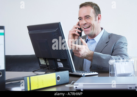 Businessman talking on mobile phone and smiling Banque D'Images