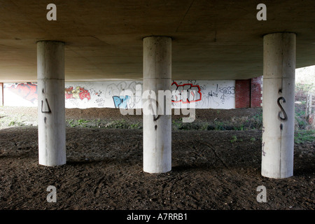 Le métro sous la route de graffiti et main boueuse imprime sur colonnes de soutien Banque D'Images