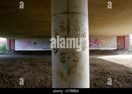 Le métro sous la route de graffiti et main boueuse imprime sur colonnes de soutien Banque D'Images