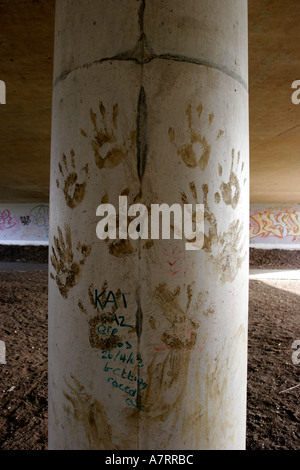 Le métro sous la route de graffiti et main boueuse imprime sur colonnes de soutien Banque D'Images