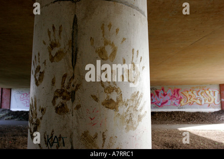 Le métro sous la route de graffiti et main boueuse imprime sur colonnes de soutien Banque D'Images