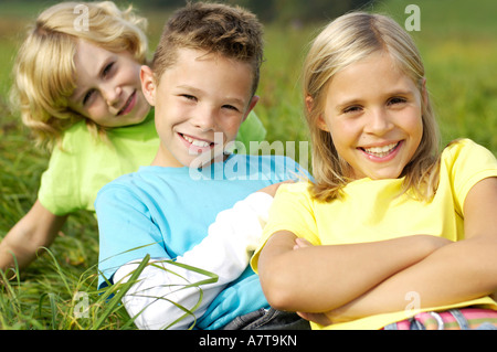 Portrait de frère et soeurs smiling in field Banque D'Images