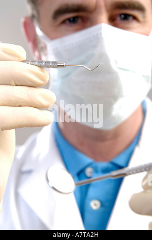 Portrait of male dentist holding suppression et la plaque miroir incliné Banque D'Images