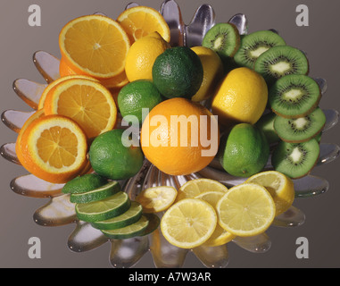 Les oranges, citrons, limes et les kiwis, complet ou en tranches, dans la coupe de fruits pour cocktail Banque D'Images