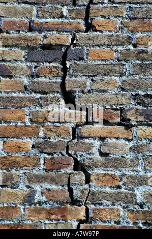 Un vieux mur de briques avec une grande fissure dans c Banque D'Images