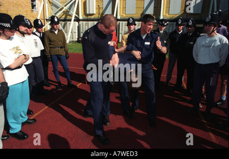 La police métropolitaine de l'ordre public la formation des instructeurs démontrant les méthodes d'encadrement et d'arrestation de ses collègues policiers, Londres, Royaume-Uni. Banque D'Images