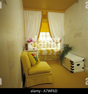 Canapé jaune et blanc peint dans la poitrine chambres-salons avec rideaux blancs au-dessus jaune +fenêtre blanche fauteuil avec coussins assortis Banque D'Images