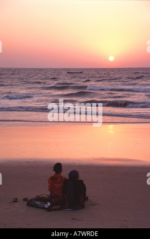 GOA, Inde. Un jeune couple bénéficiant d'un magnifique coucher de soleil sur la mer d'Oman de Benaulim sur plage de Colva. Banque D'Images