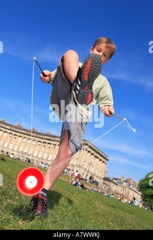 Jeune garçon jouant avec un diabolo jouet spinning in park Banque D'Images