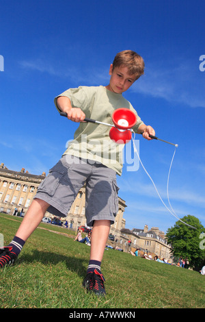 Diabolo jeune garçon broyage avec toy diabolo dans un parc Banque D'Images