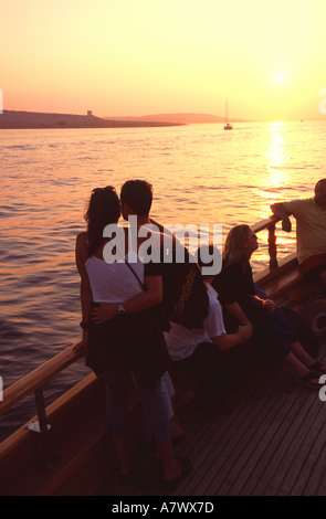 Malte. Un jeune couple appréciant une croisière au coucher du soleil le long de la côte maltaise. Banque D'Images