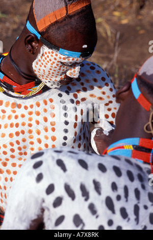 Un guerrier Karo carrosserie peinture met sur un autre homme Karo, l'Éthiopie dans la région de la rivière Omo, en Afrique. Banque D'Images