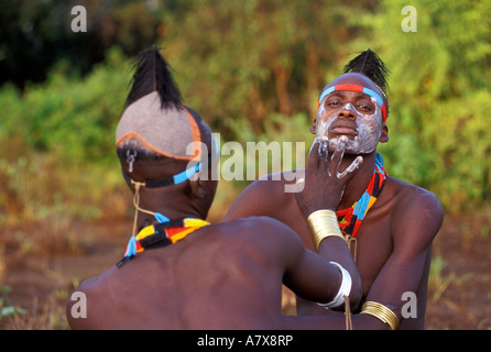 Un guerrier Karo carrosserie peinture met sur un autre visage de l'homme Karo, dans la région de la rivière de l'Omo en Éthiopie, en Afrique. Banque D'Images