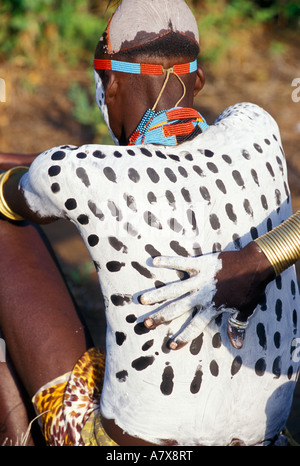 Un guerrier Karo carrosserie peinture met sur un autre homme Karo, l'Éthiopie dans la région de la rivière Omo, en Afrique. Banque D'Images