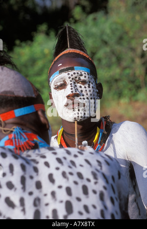 Un guerrier Karo carrosserie peinture met sur un autre homme Karo, l'Éthiopie dans la région de la rivière Omo, en Afrique. Banque D'Images