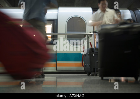L'Asie, Chine, Shanghai, image floue de passagers débarqués de lévitation magnétique (Maglev) train à la gare de l'aéroport. Banque D'Images