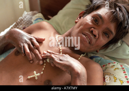 L'Asie, Philippines, l'île de Panay, Santa Barbara, jeune homme souffrant de la lèpre est titulaire crucifix à Western Visayas Sanitarium Banque D'Images