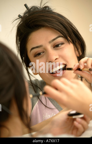 Woman applying makeup Banque D'Images