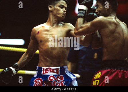 Sud-est de l'Asie, Thaïlande, Bangkok, Sweat-imbibé fighter offre punch au cours de Kick Boxing Muay Thai (match) Banque D'Images