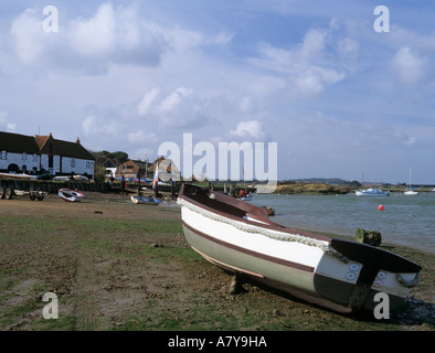 Bateau en bois amarré sur la plage boueuse dans le port à marée basse. Burnham Overy Staithe Norfolk England UK Banque D'Images