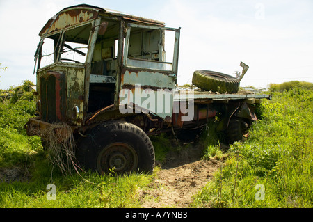 La rouille vieux camion à plateau abandonné en campagne dans le West Sussex, Angleterre, Royaume-Uni. Banque D'Images