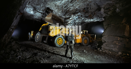 Exploitation minière pour le transport, la gestion et le traitement du minerai d'or. Chargeur frontal souterrain dans une mine d'or, déplaçant le minerai vers le convoyeur. Ghana Banque D'Images