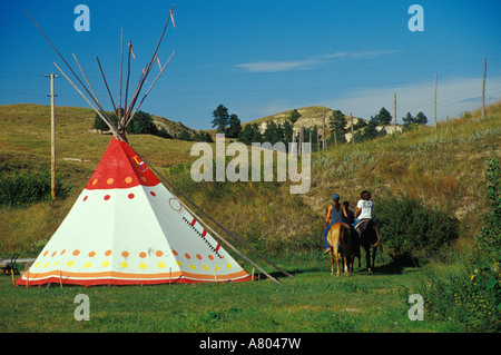 De l'équitation près de tipi, la réserve indienne de Pine Ridge, Dakota du Sud Banque D'Images