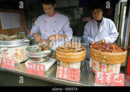 Chine HANGZHOU travailleurs chinois préparer des aliments traditionnels, y compris les têtes et pieds de canard canard dans une zone de restauration Banque D'Images