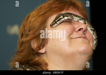 Un serpent python propriétaire vous permet de monter sa balle sur son visage Banque D'Images