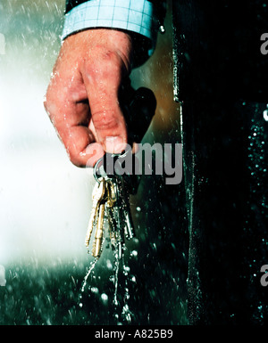 Mans part avec des clés dans la pluie Banque D'Images