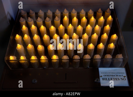 Les bougies artificielles allumé lorsque payés à l'aide de monnaie dans la fente de l'église catholique romaine El Salvador Espagne Nerja Banque D'Images