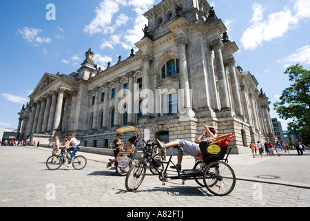 Un guide touristique en attente sur son vélo-taxi à l'extérieur le Reichstag à Berlin, Allemagne Banque D'Images