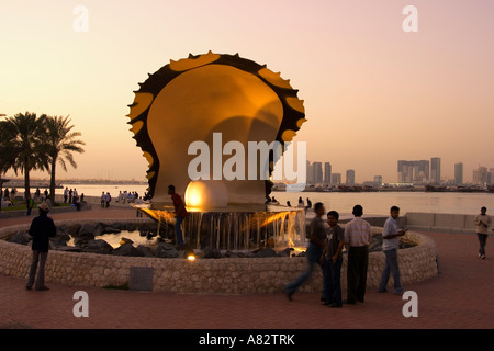 Doha Qatar pearl oyster fontaine avec le long de la côte de Doha au coucher du soleil Banque D'Images