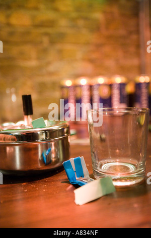 Nature morte avec un verre, une boîte à lunch, papier et autres objets placés sur une table contre un arrière-plan flou Banque D'Images