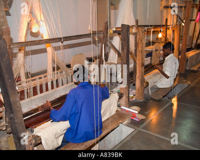 Varanasi Benares Uttar Pradesh Inde Hommes assis travailler à tisser tissage tissu de soie en usine Banque D'Images