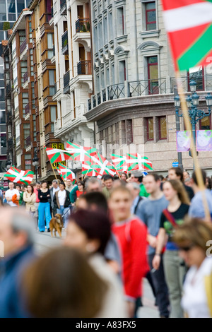 Le drapeau Basque, l'Ikurrina, est tenue en altitude au cours d'une manifestation nationaliste basque, Bilbao, Espagne. Banque D'Images