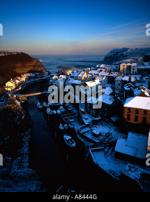 Les maisons couvertes de neige au crépuscule à Staithes sur la côte du Yorkshire en Angleterre Banque D'Images