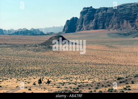 La Jordanie. Le désert de Wadi Rum. L'un des plus spectaculaires du pays. Les usagers de bédouins du désert à dos de chameau sont de la police. Banque D'Images