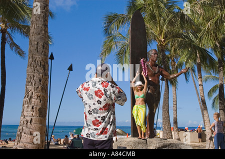 Couple de touristes prendre des photos lors de la statue de Duke Kahanamoku Kuhio Beach Park à Waikiki Beach Honolulu Oahu Hawaii Banque D'Images