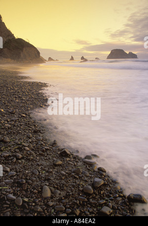 Surfez sur cailloux plage Oceanside Oregon Banque D'Images