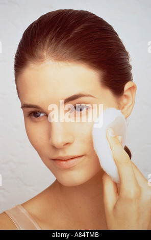 Studio intérieur closeup portrait of young woman applying make-up. Banque D'Images