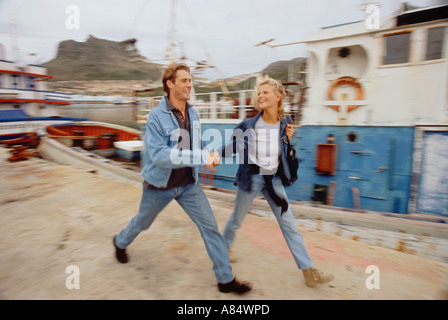 Jeune couple en train de marcher le long des quais du port Banque D'Images