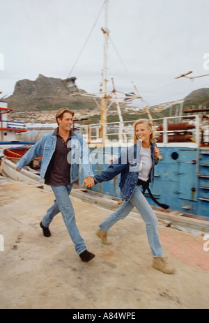 Jeune couple en train de marcher le long des quais du port Banque D'Images