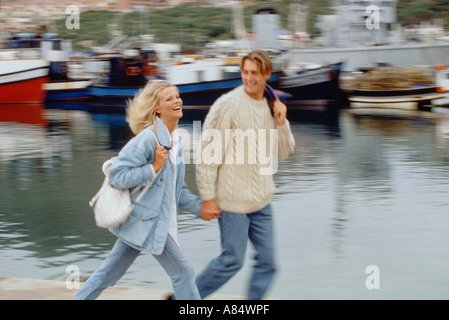 Jeune couple en train de marcher le long des quais du port Banque D'Images