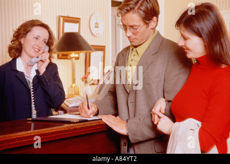 Jeune couple l'enregistrement à la réception de l'hôtel. Banque D'Images