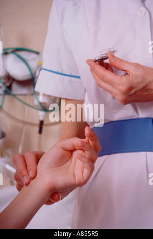 Infirmière pédiatrique de l'hôpital taking pulse fréquence cardiaque de jeune fille enfant patient. Poignet et bras close-up. Banque D'Images